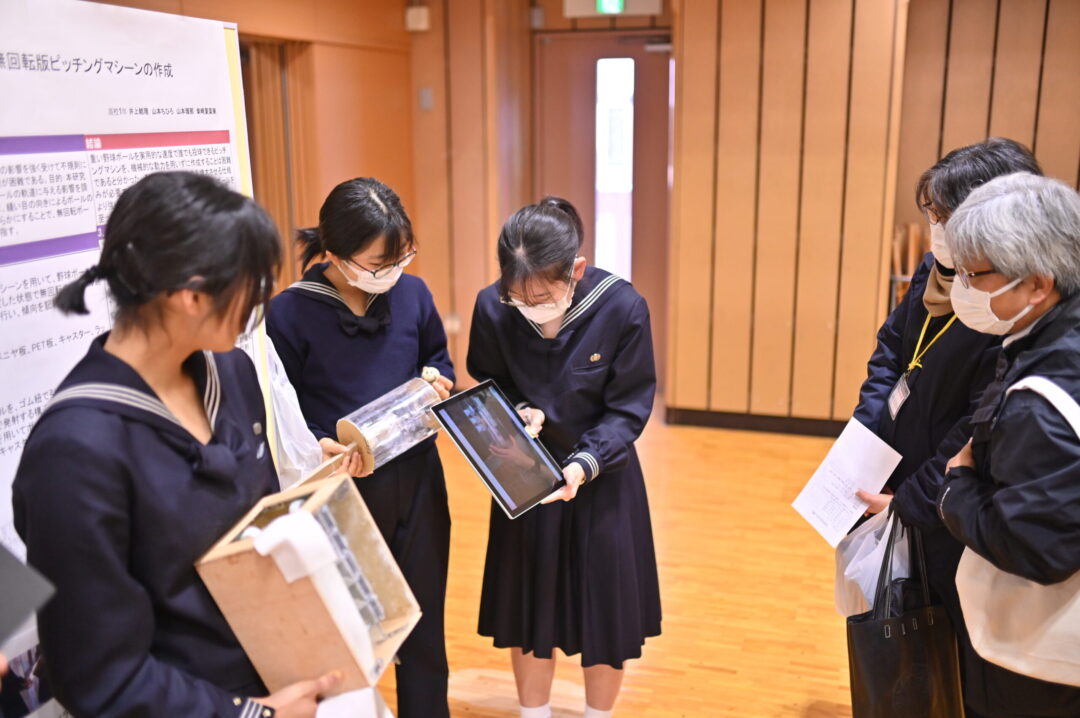 自作の実験器具を動かして見せて